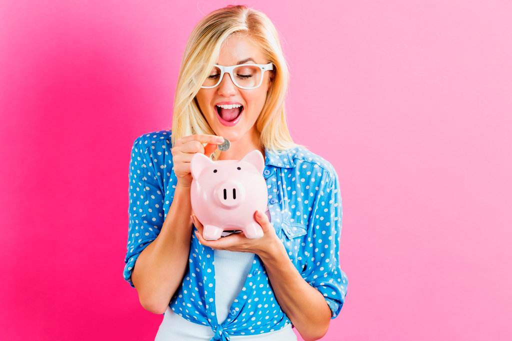 blonde vrouw met roze achtergrond stop euro in spaarpot